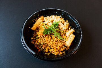 Wok rice cooked with soy sauce, vegetables and chicken pieces.