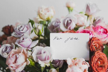 white card for a bouquet with the inscription for you in a bright beautiful bouquet of flowers roses 