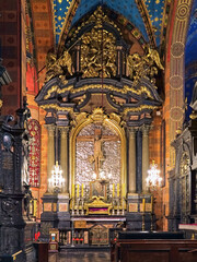 Fototapeta na wymiar Krakow, Poland. Baroque altar of the Holy Cross in the southern nave of St. Mary's Basilica with Crucifix of Veit Stoss. The crucifix was created in 1496 by the German sculptor Veit Stoss.