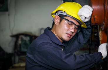 Asian male worker Dressed in a uniform, helmet and safety glasses, take a nap.