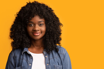 Young smiling african american young woman over yellow background, closeup