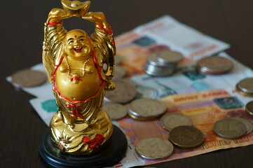Figure of the Golden Buddha. Next to cash bills.