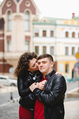 rock style couple in the old City. Happy lovers on the walk outside. Funny couple pair weared in black leather jackets. Romantic walk for young happy family. 