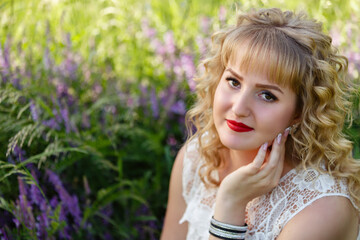 Naklejka premium Young woman in blooming near the tree. Spring story. Romantic look with white lace dress. Happy girl in beautiful spring day. Pretty slim blonde woman, caucasian. Portrait
