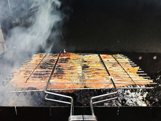 Large chunks of red fish, cooked on wood, grilled salmon, fragrant healthy food outdoors.