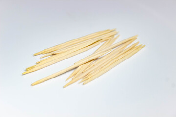 Several wooden toothpicks close-up on a white background.