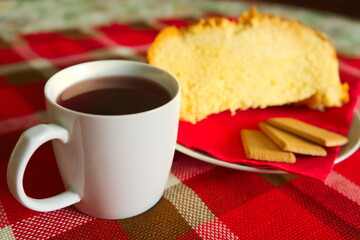 Fetta di panettone con biscotti  e tè su tovaglia tartan rossa