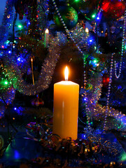 burning candle and christmas tree with ornaments 