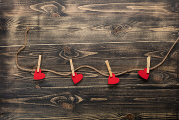 Hearts hanging on rope on wooden background
