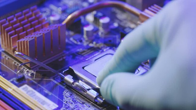 Male hand Installing a computer processor CPU. Personal computer repair. Modern Electronic Manufacturing Factory Design Engineer Holds Microchip.