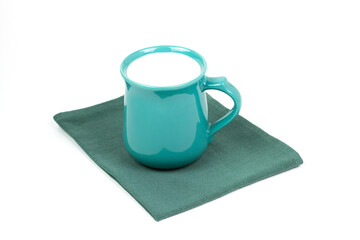 Green cup of milk on green cloth isolated on white background.