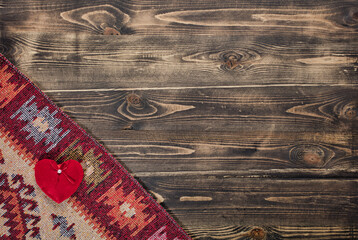Tablecloth with heart on wooden background.