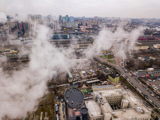 Obraz na płótnie Canvas Aerial drone view. The building of the Kiev railway station through the white smoke from the chimneys.