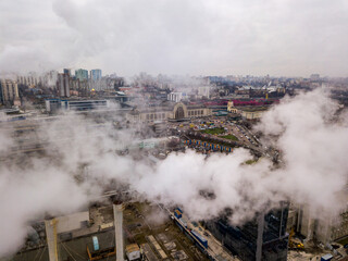 Fototapeta na wymiar Aerial drone view. The building of the Kiev railway station through the white smoke from the chimneys.