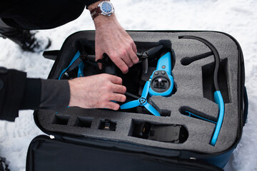 Blue quadcopter in a bag. A man packs a quadcopter into a bag.