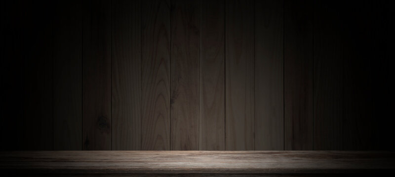 Empty wooden table on dark background,used as a studio background wall to display your products.