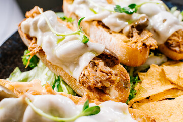 Dish of ciabatta bread with pulled meat and melted goat cheese