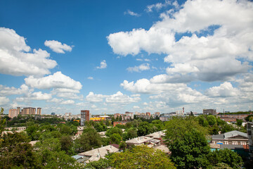 Fototapeta premium White clouds in the blue sky over the city and trees Clear blue sky with plain white cloud with space for text background