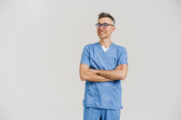 Happy white-haired medical doctor smiling and posing with arms crossed