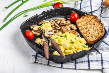 scrambled eggs with onion and mushrooms in frying iron pan, Food recipe background. space for text. top view