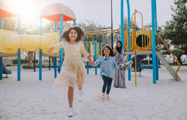 Mom and daughters spending time together at the park, in Dubai