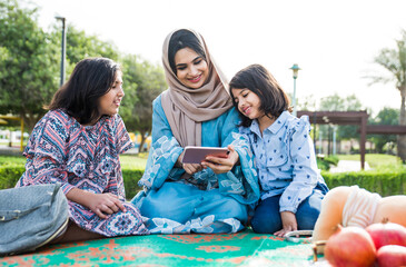 Mom and daughters spending time together at the park, in Dubai