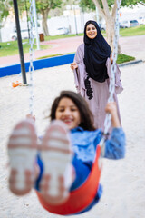 Mom and daughters spending time together at the park, in Dubai