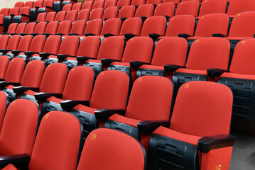 Rows of red chairs in a theatre auditorium