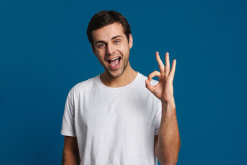 Happy unshaven guy smiling and showing ok sign at camera