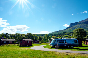 Wunderschöner Campingplatz mit einem alten Wohnmobil in den Bergen mit Sonnenschein und blauem Himmel