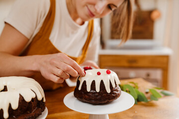 Caucasian pleased pastry chef woman making chocolate cake