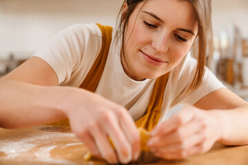 Obraz na płótnie Canvas Caucasian happy pastry chef woman smiling while making tart