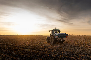 Fototapeta premium Tractor spreading artificial fertilizers in field