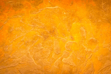 The gold color wall for the background. Gold stone texture background. Gold or foil wall texture backdrop design. Walls are decorated with gold-colored filters. Cement orange wall background.