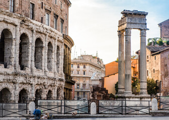Obraz premium A street of Rome with ancient and medieval houses at sunset and a praying man
