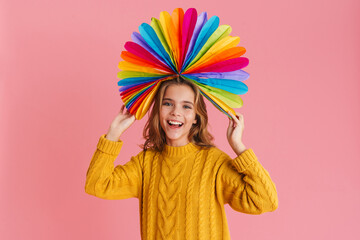 Fototapeta na wymiar Joyful girl laughing while posing with multicolored fan on her head