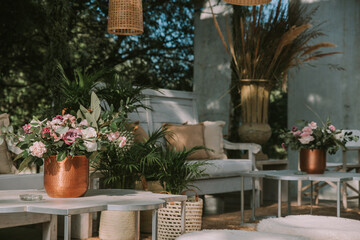 Fototapeta na wymiar Armchairs and garden table adorned with pots, flowers and imitation leather fabrics.