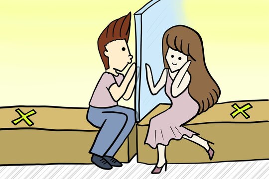 A lovely dating couple sitting and kissing on the mirror in a new normal concept, social distancing and no contact on Valentine's day during COVID-19 coronavirus outbreak spreading