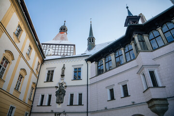 Obraz premium Medieval renaissance water castle with half-timbered tower with snow in winter sunny day, Historic Romantic chateau Blatna near Strakonice in southern Bohemia, Czech Republic