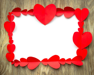 Valentine's Day background. Red paper hearts are lined with rectangle, on a wooden background with place for text. Bright colorful hearts for postcards. - 404883463