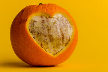 Valentine's Day background. The orange is juicy and fresh with a carved heart in its rind. Carving for the holiday. - 404883627