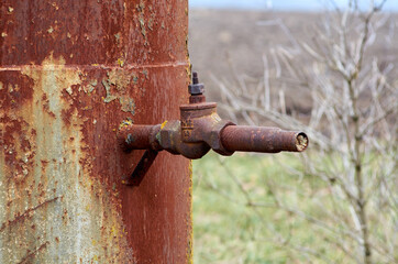 Rusty faucet at the bottom of an old water tower