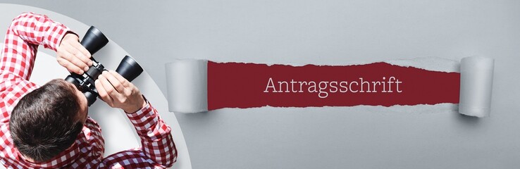 Antragsschrift. Mann (Anwalt) bei Beobachtung mit Fernglas. Fokus auf Text/Wort in einem Papier...