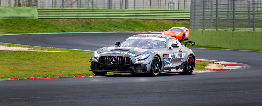 Spectacular Motorsport Scenic View Of Supercar Touring Mercedes AMG Racing Car In Action Out Of Curve On Kerbs Evening Dark Light