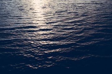 Wavy surface of dark water in the sea during sunset