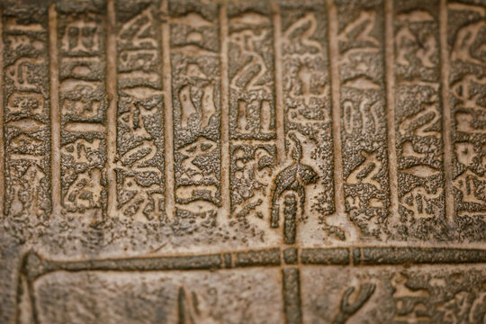 Shallow depth of field (selective focus) and close up footage with Egyptian hieroglyphs on a historic replica.