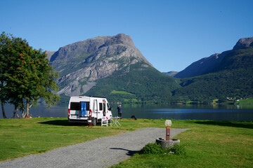 Wohnmobil auf einem sehr schönen Campingplatz mit Bergen in Hintergrund und See