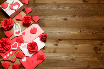 Love, Valentine's, women's day, relations, romantic design with gifts and envelope, wrapped in brown craft paper, tied with twine with bows, labels, handmade paper roses and hearts on wooden boards