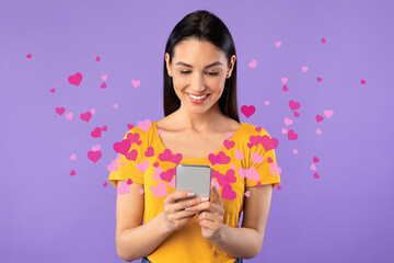 Obraz na płótnie Canvas Woman sending love message on smartphone, hearts flying away