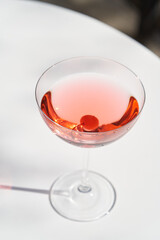 Red cocktail in martini glass with cherry. Exotic cocktail